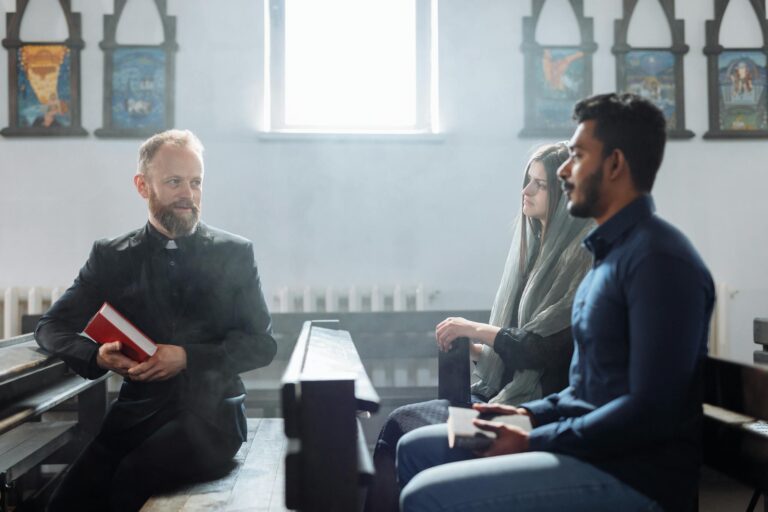 A priest converses with two people inside a church, highlighting religious dialogue and community.