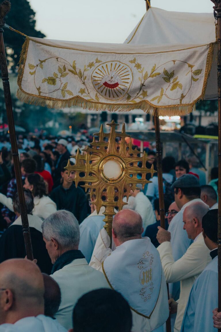 A religious procession featuring a monstrance in an urban outdoor environment.
