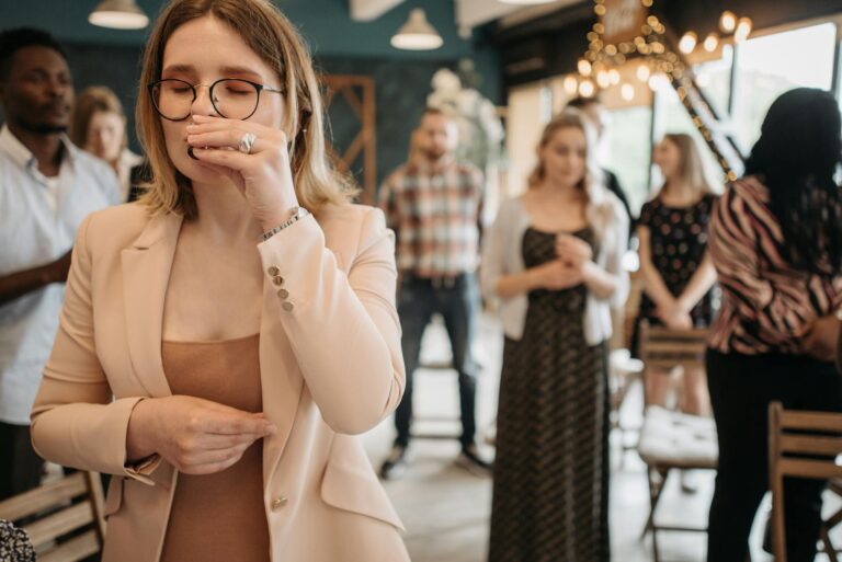 People gathered for prayer in a cozy, modern indoor space, highlighting a sense of community and faith.