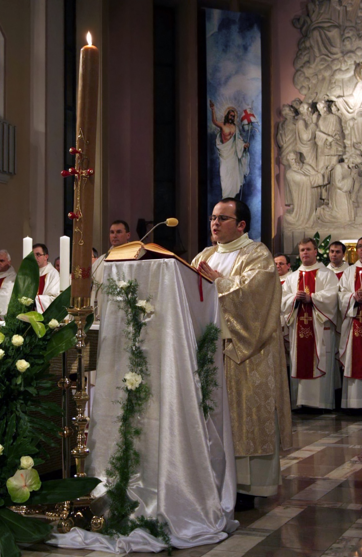 The Easter Vigil: the paschal candle in a darkened church.