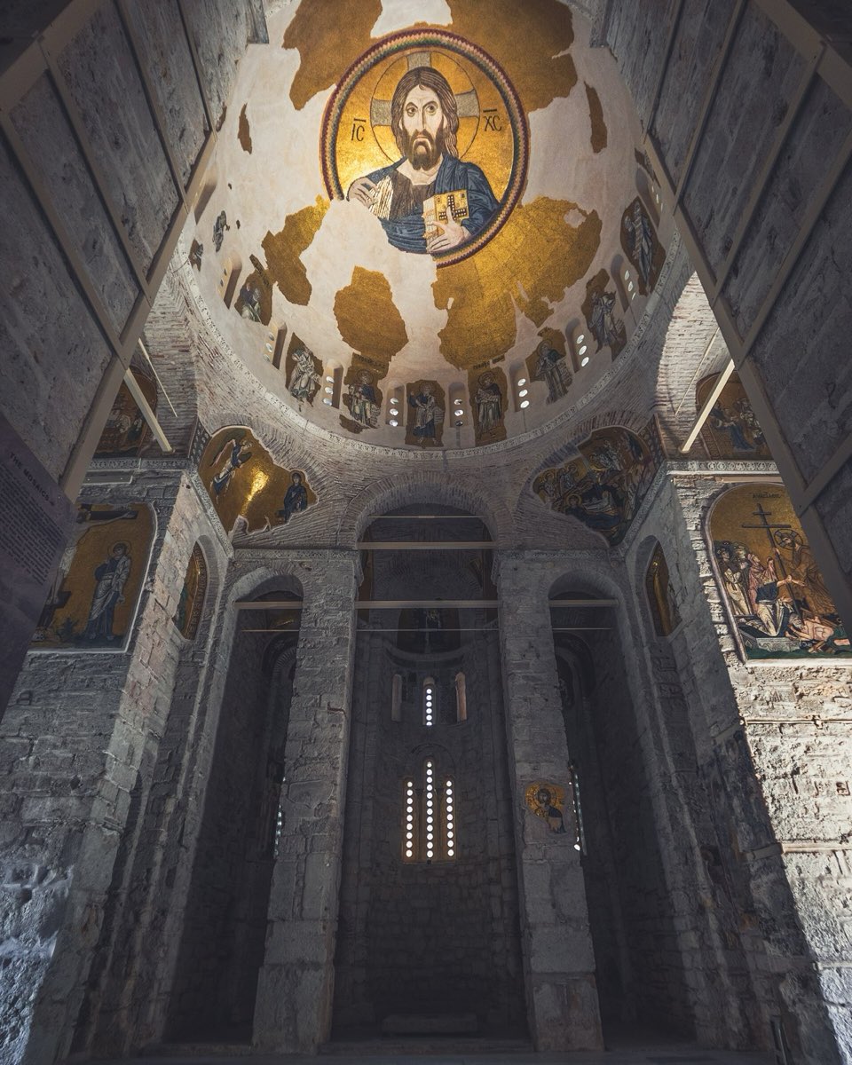 Christ Pantokrator in gold mosaic at the crown of a dome, above figures of the prophets between the windows of the drum